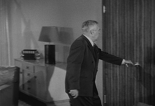 Perry reaches for a round door knob.